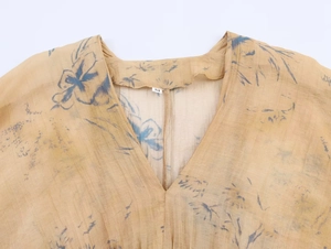 Detail of V-neck collar on women's slim floral top showing size M tag and sheer fabric