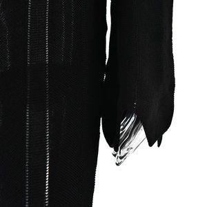 Detailed close-up of black ribbed knit fabric texture on sleeve and bodice of a slim dress