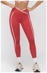 Dettaglio dei leggings yoga rossi con vita a incrocio e bordi bianchi a contrasto