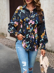 Détail d'une chemise noire à imprimé fleuri avec poignets froncés et boutonnage frontal