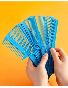 Close-up of blue plastic hair comb set including wide-tooth and styling combs in hand