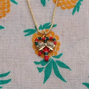 Christmas necklace with red green candy cane heart pendant and golden bow detail