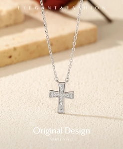 Macro shot of silver cross pendant necklace with sparkling moissanite stones on stone base