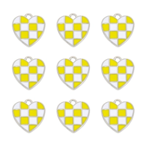 Nine heart-shaped yellow and white checkered enamel pendants on white background