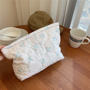 Detailed wave quilting and blue floral pattern on soft cotton quilted cosmetic pouch