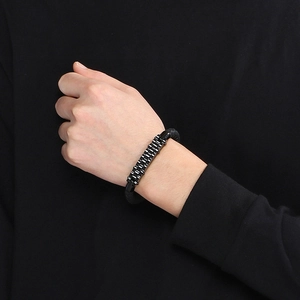 Close-up of men's braided leather bracelet with stainless steel watchband chain details