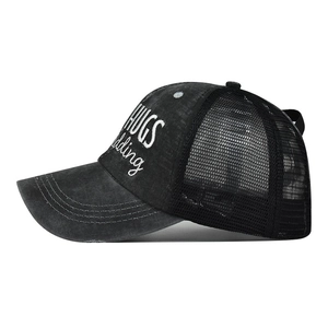 Detail of black distressed trucker hat with HUGS embroidery and breathable mesh back