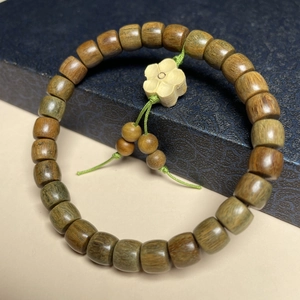 Detail von Sandelholz-Armband mit Trommelperlen und geschnitztem Pflaumenblüten-Anhänger