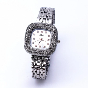 Detailed view of silver square dial watch with sparkling rhinestones and metal band