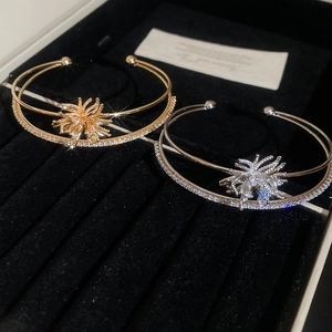 Close-up of gold and silver firework zircon bracelets in a black velvet jewelry box