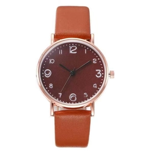 Gros plan d'une montre en or rose avec bracelet en cuir marron et grand cadran