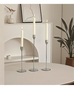 Close-up of three-piece silver metal candle holders with minimalist nordic design