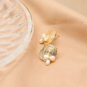 Vintage 18k gold plated pearl stud earrings with zircon accents on silk background