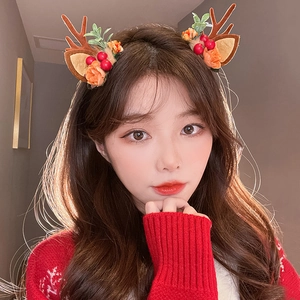 Cute Christmas reindeer antler headband with green leaves and red berries on a model