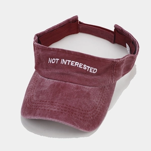 Detail of burgundy washed cotton sun visor with NOT INTERESTED white embroidery