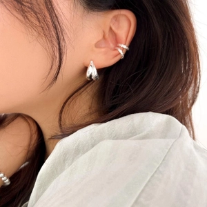 Detail of 925 sterling silver shell texture earrings and minimalist ear cuffs on model