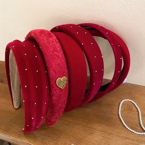 Detail of red velvet and tweed headbands with rhinestones and golden heart charm decorations