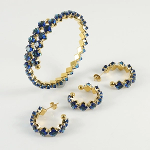 Detailaufnahme von goldenem Schmuckset mit blauen quadratischen Edelsteinen und Creolen