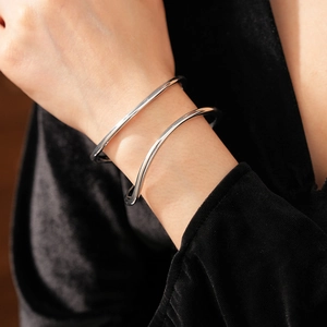 Détail macro du bracelet ouvert double couche minimaliste en argent au fini poli