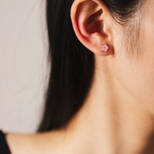 Minimalist s925 sterling silver pink flower stud earring worn by a model in close-up