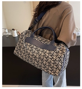 Dettaglio borsa da viaggio jacquard con cinturini in pelle blu e motivo floreale