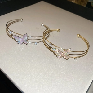 Detail of double-layered butterfly open bangles with pink and white zirconia inlays