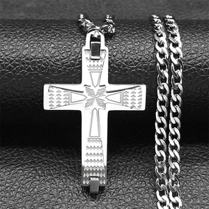 Detailed macro view of a silver vintage engraved cross pendant on textured black leather