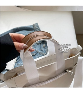 Détail du sac cabas en toile avec des poignées renforcées en cuir synthétique marron