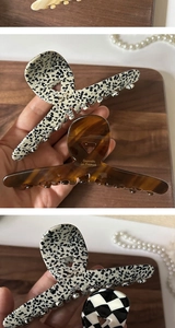 Detailed view of tortoiseshell and checkered acetate hair claws on a wooden tray