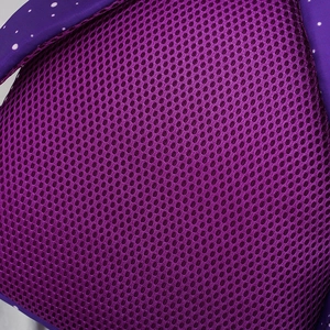 Detail of purple breathable honeycomb mesh padding with white polka dot fabric edge