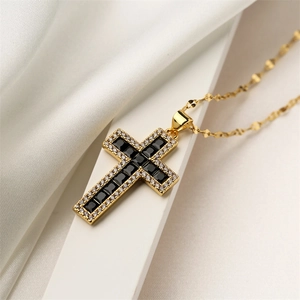 Detail of gold cross pendant featuring black square and clear round cubic zirconia