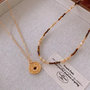 Gold plated compass necklace with brown tiger eye stone and layered vintage beaded chains