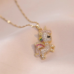 Macro shot of gold unicorn pendant with colorful cubic zirconia on pink silk