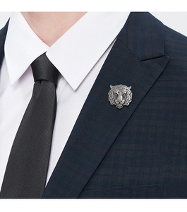 Detail of silver tiger head brooch pinned on a navy blue suit for a professional look
