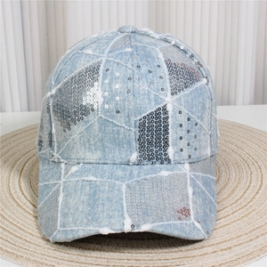 Macro view showing light blue denim texture with silver sequins and white stitching detail