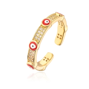 Macro shot of gold-plated evil eye ring with red enamel and pavé zircon details