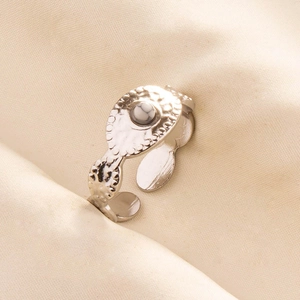 Detail of adjustable silver ring featuring white marble stone and hammered metal texture
