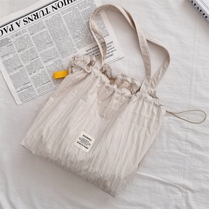 Détail du sac cabas rayé beige avec volants à cordon et étiquette tissée SOZAKKA