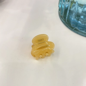 Detailed view of mini amber acetate hair claw clip with France Handmade engraving