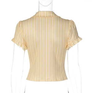 Détail d'une chemise d'été à rayures jaunes et beige avec poignets à volants tissés