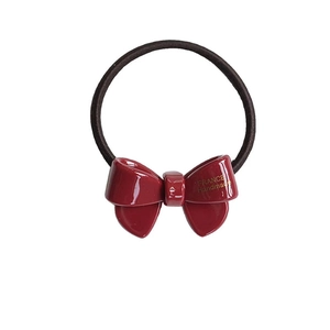 Elegant deep red acetate bow hair tie with black elastic band on white background