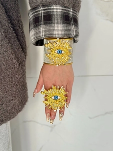 Detalle de brazalete vintage de ojo turco y anillo de sol con diamantes