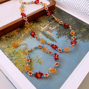 Vue à plat d'un collier et d'un bracelet en perles florales sur un livre vintage