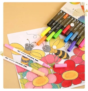 Detailed macro view of dual-tip watercolor markers scattered on a colorful coloring book