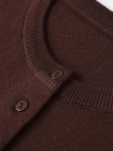 Close-up of crew neck ribbing and tonal buttons on dark brown fine knit sweater