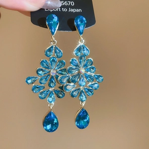 Elegant floral teardrop earrings with sparkling blue crystals and gold-plated fringe