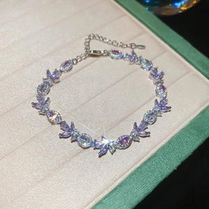 Macro shot of leaf shaped purple and pink zirconia stones on a silver adjustable bracelet