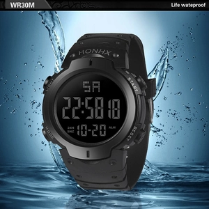 Close-up of waterproof digital sports watch with black rubber strap and functional LCD display