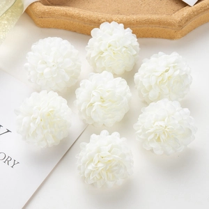 Detail of eight white artificial hydrangea flower heads on a wooden tray with decor