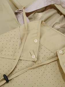 Détail du tissu du chapeau beige avec pores respirants et boutons-pression en résine